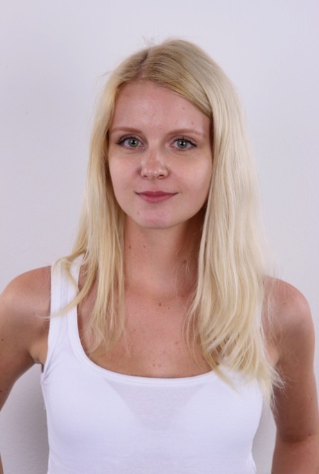 Natural blond Aneta stands stiff as a board while getting naked before sitting