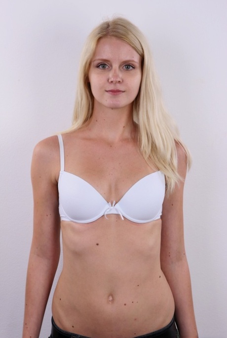Natural blond Aneta stands stiff as a board while getting naked before sitting