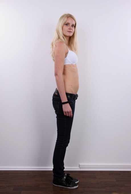Natural blond Aneta stands stiff as a board while getting naked before sitting