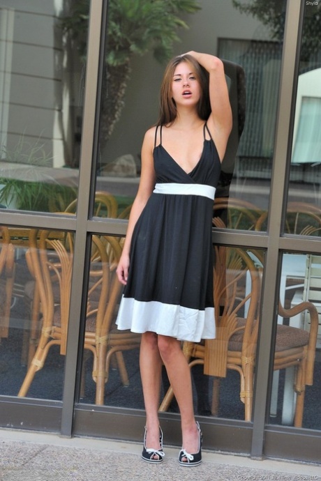 Naughty teen girl hikes up her dress in public and spreads her pink snatch