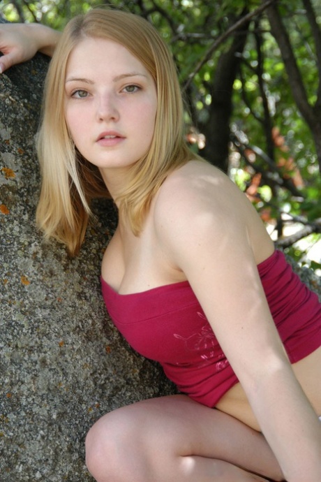 Young solo girl flashes her upskirt panties while climbing a rock