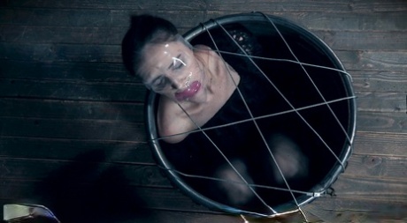 Brunette teen Luci Lovett wears stockings while being kept in bondage