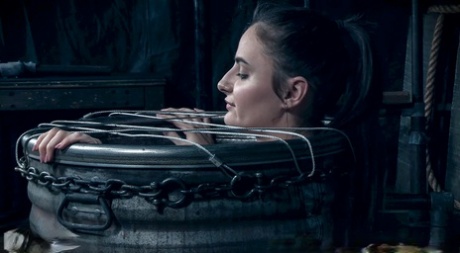 Brunette teen Luci Lovett wears stockings while being kept in bondage