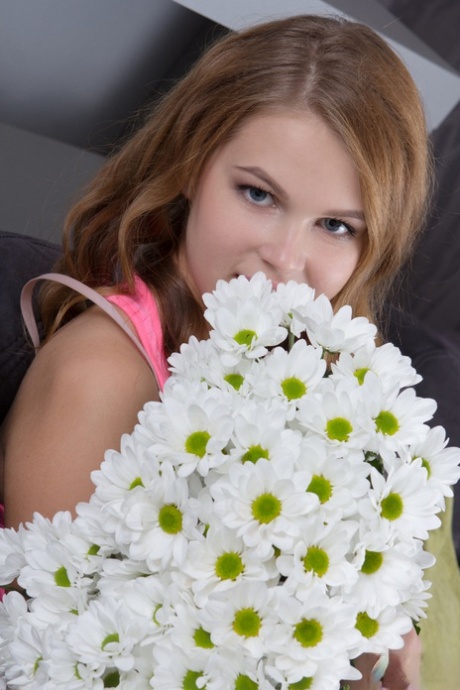 Cute teen Eveline frees her puffy pussy from panties with a daisy in her hair