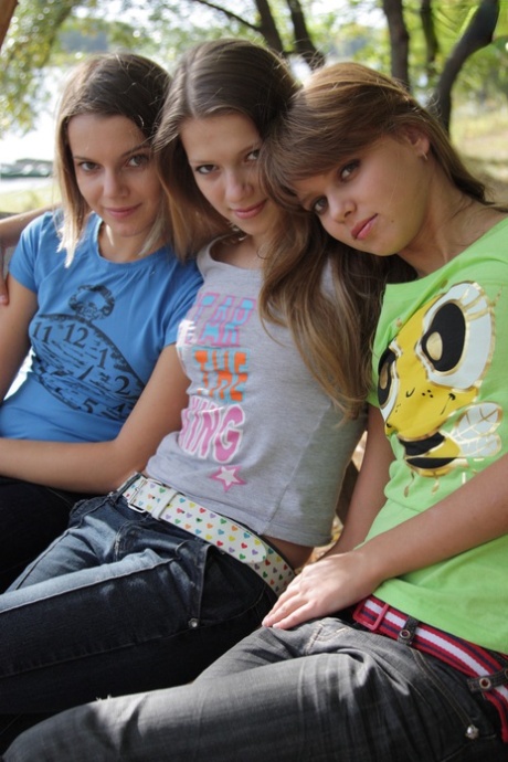 3 young girls remove T-shirts and jeans to model naked on park bench