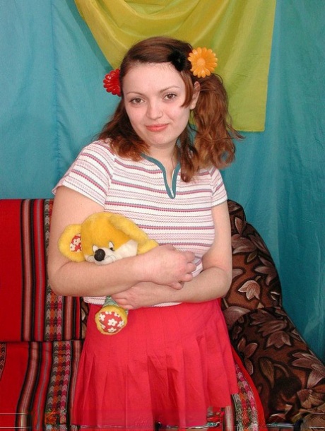 Young looking redhead holds a Teddy Bear before having sex with her boyfriend