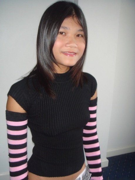 Young Asian girl drinks a beer while disrobing to arm socks and thigh highs