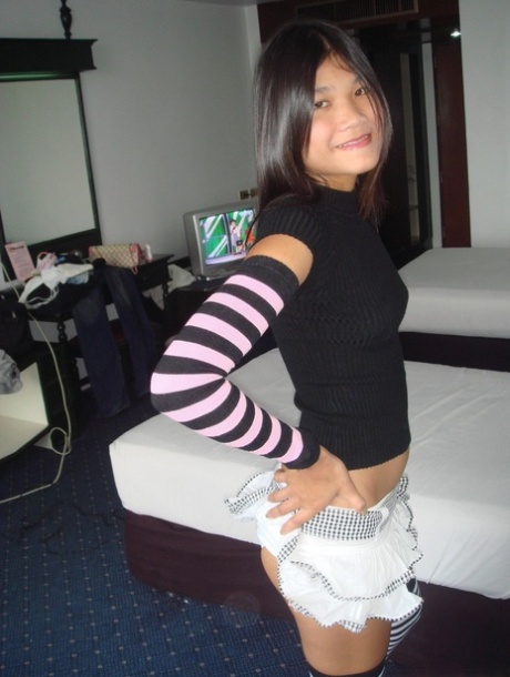 Young Asian girl drinks a beer while disrobing to arm socks and thigh highs