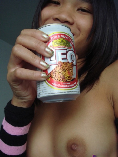 Young Asian girl drinks a beer while disrobing to arm socks and thigh highs