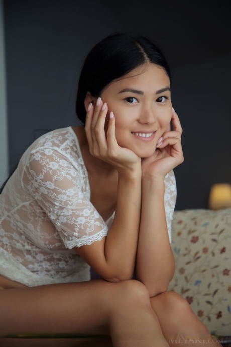 Asian teen Kimiko shows the bottoms of her bare feet during a nude session