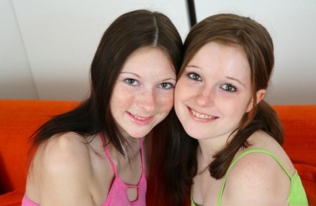 Young lesbians strip each other naked before licking pussies on a sofa