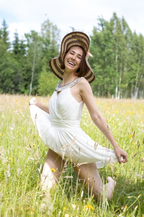Teen amateur Ava bares her skinny body in a field while wearing a sun hat