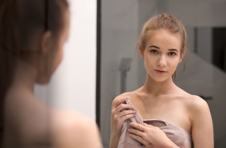 Young looking girl Jessica Portman shows her nice ass while naked by a mirror