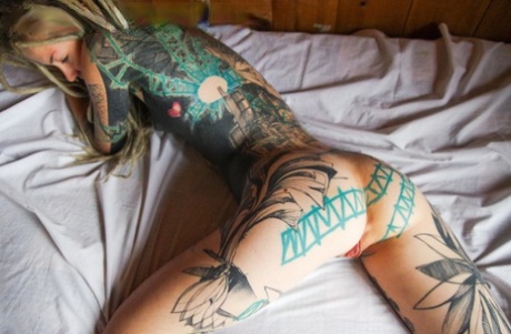 Heavily tattooed girl licks a penis while modelling in the nude
