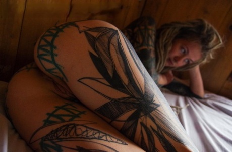 Heavily tattooed girl licks a penis while modelling in the nude