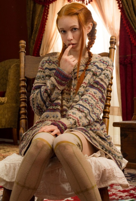 Young looking redhead Dolly Little gets naked in over the knee socks