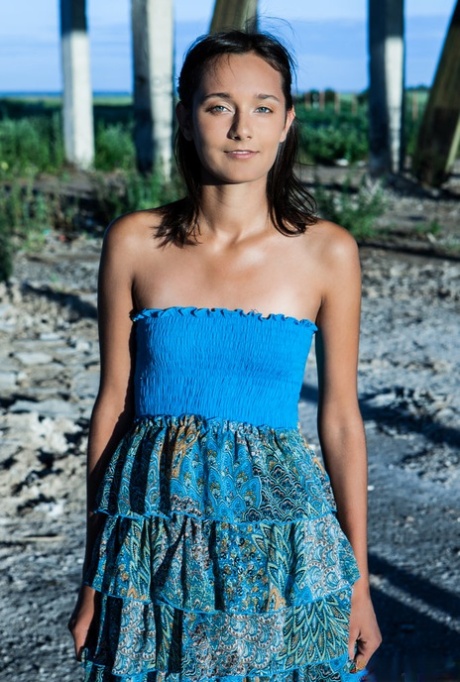 Young brunette Chandra gets totally naked outdoors underneath a structure
