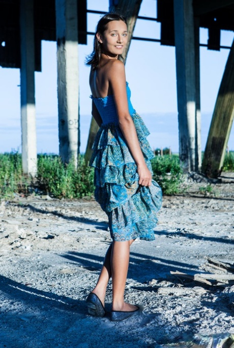 Young brunette Chandra gets totally naked outdoors underneath a structure
