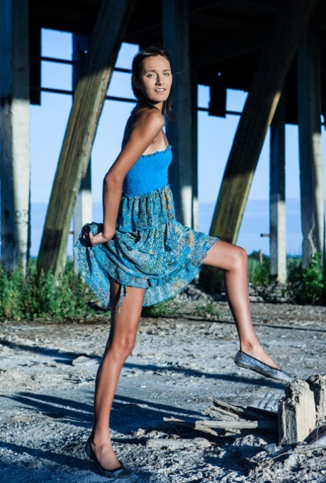 Young brunette Chandra gets totally naked outdoors underneath a structure