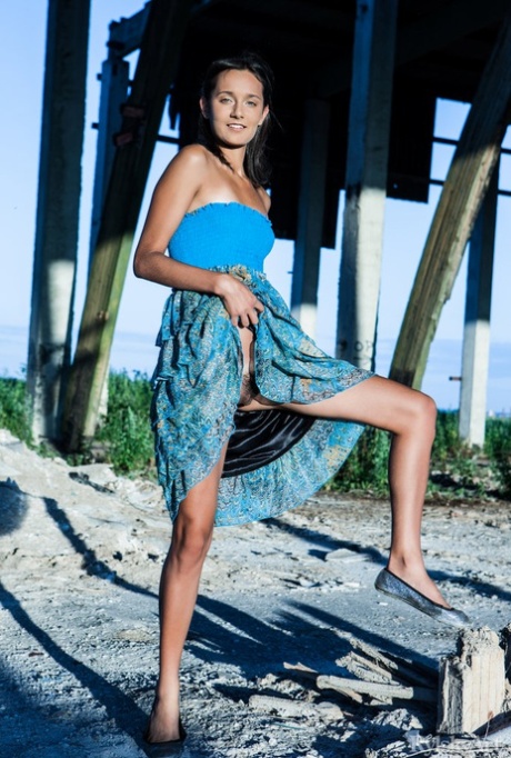 Young brunette Chandra gets totally naked outdoors underneath a structure
