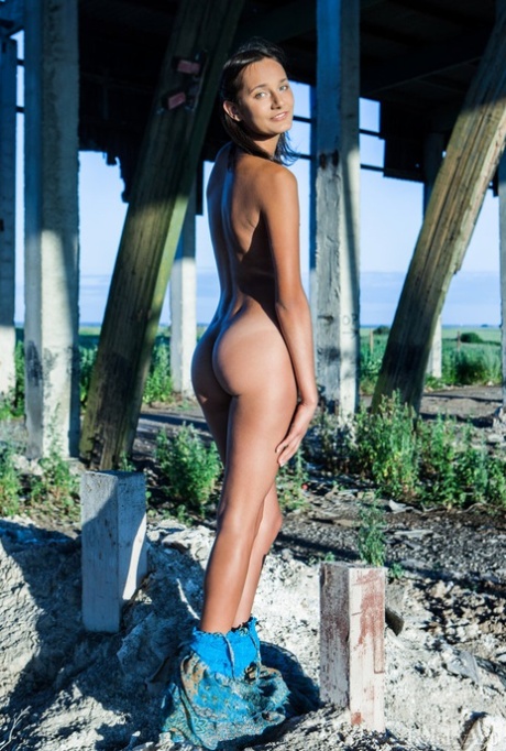 Young brunette Chandra gets totally naked outdoors underneath a structure
