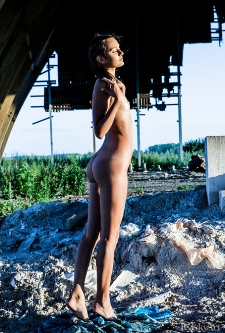 Young brunette Chandra gets totally naked outdoors underneath a structure