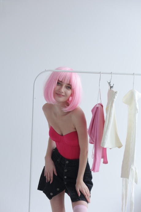 Cute teen with pink hair Atika gets completely naked on a sofa