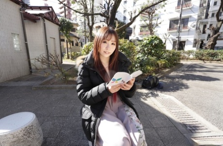 Japanese teen Ryo Ayase reads a book outdoors before going nude indoors