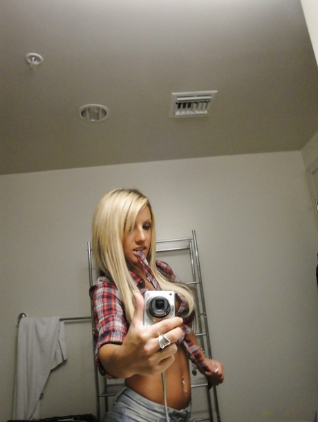 Perky blondie with piercing undressing and making selfies in the bath