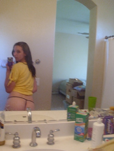 Amateur teen babe Casey posing topless in her black g-string panties