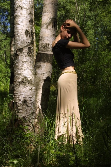Adorable petite teen Gillian unveils her hot body and poses in the woods