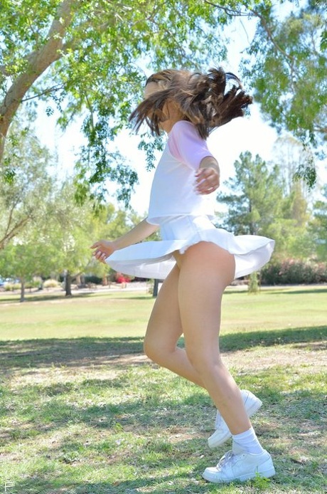 Brunette cutie Kelly reveals her tiny tits and fingers her snatch in the park
