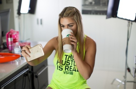 Blonde teen Tahlia Paris shows her big tits in a neon green top in the kitchen
