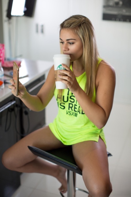 Blonde teen Tahlia Paris shows her big tits in a neon green top in the kitchen