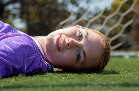 Sporty redhead teen Bailey Rayne flashes her tight ass on the soccer field
