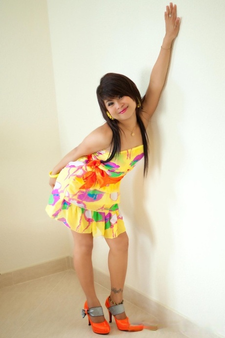 Pretty Thai teen Ni shows her shaved cunt in a hot striptease in high heels