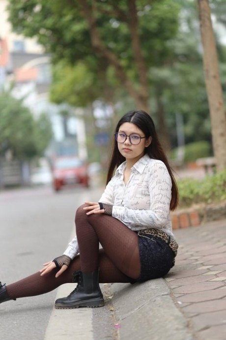 Nerdy Asian babe Natalia posing in her white blouse and denim shorts outside