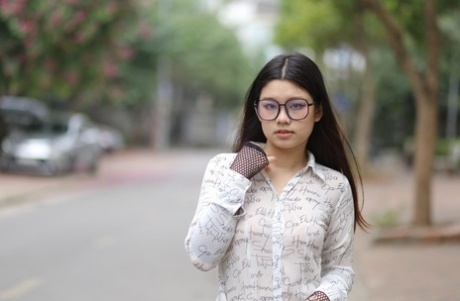 Nerdy Asian babe Natalia posing in her white blouse and denim shorts outside