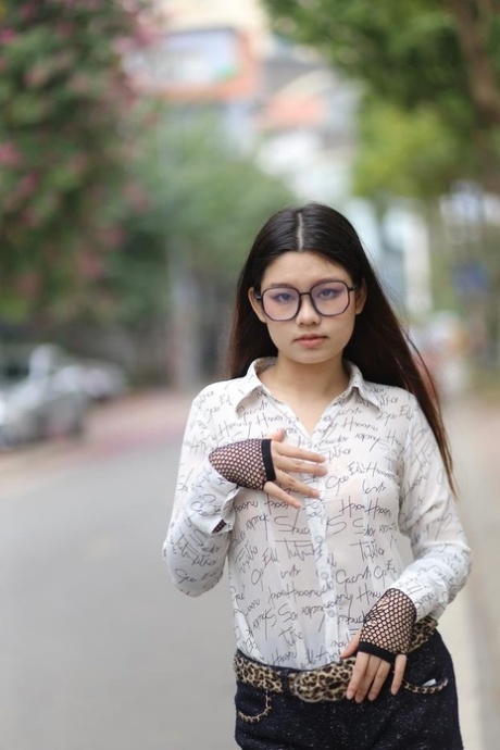 Nerdy Asian babe Natalia posing in her white blouse and denim shorts outside