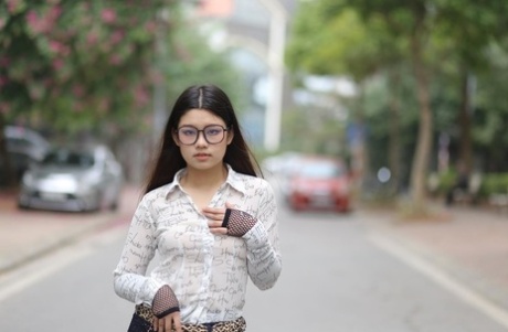 Nerdy Asian babe Natalia posing in her white blouse and denim shorts outside